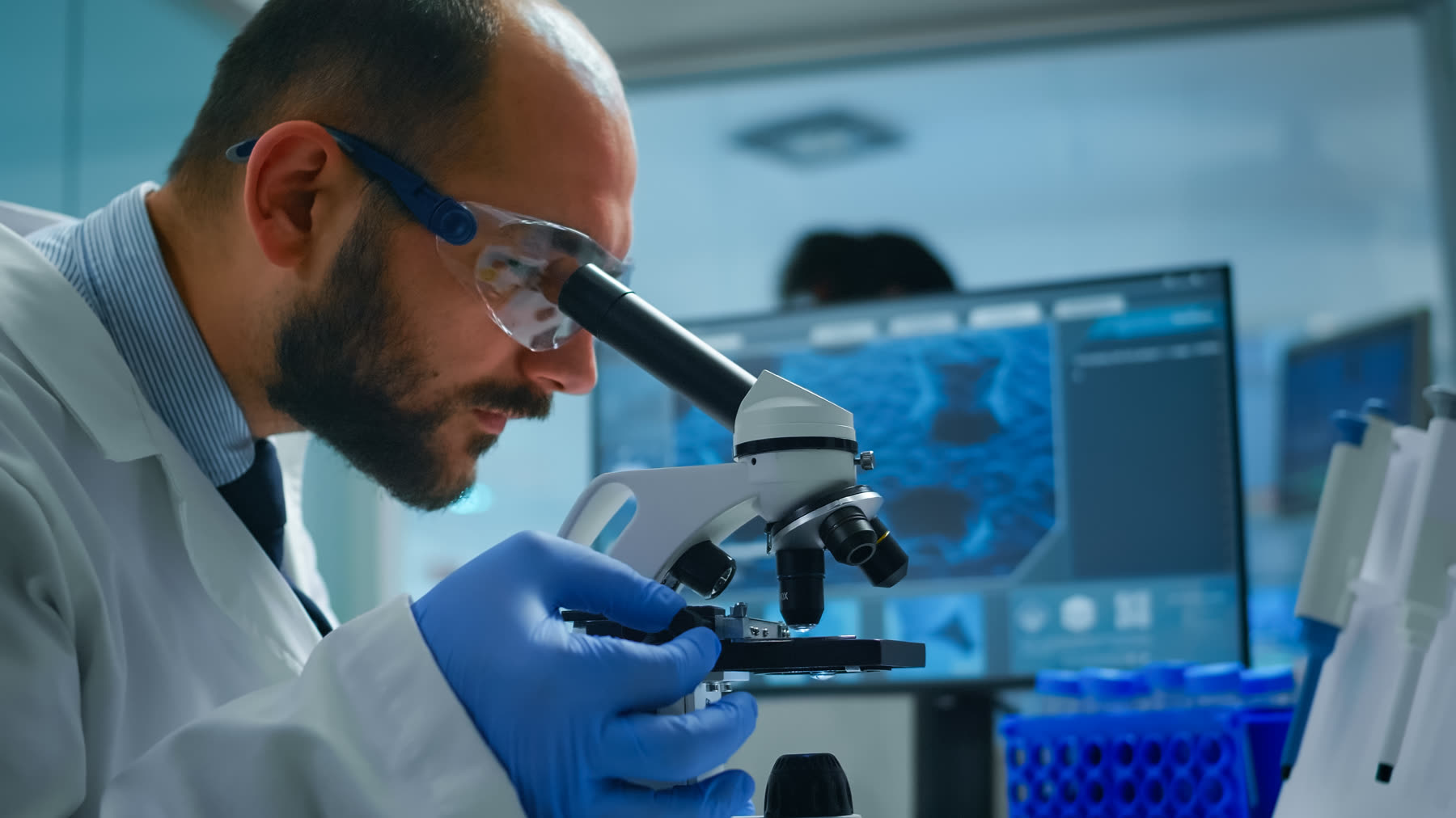 Técnico de ADH examinando una muestra al microscopio